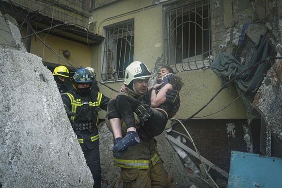 In this photo released by State Emergency Service of Ukraine on Monday, Jan. 16, 2022, a Ukrainian State Emergency Service firefighter carries a wounded woman out of the rubble from a building after a ...
