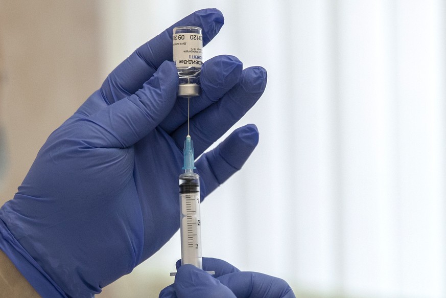 ARCHIV - 10.12.2020, Russland, Moskau: Ein medizinischer Mitarbeiter bereitet eine Spritze mit dem in Russland entwickelten Corona-Impfstoff
