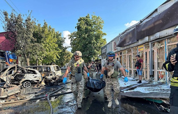 Ukrainian soldiers carrying a body on the site of destroyed market as a result of a Russian missile strike on Wednesday, September 6, 2023 in Kostiantynivka, Ukraine. At least 16 people have been kill ...