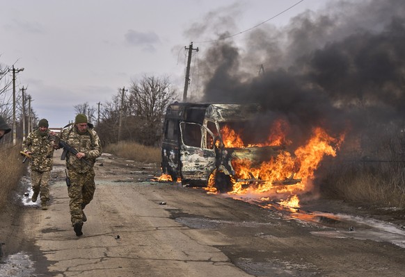 HANDOUT - 23.11.2023, Ukraine, Bachmut: Auf diesem von der ukrainischen 10. Gebirgsjägerbrigade «Edelweiß» zur Verfügung gestellten Foto gehen ukrainische Soldaten an einem Bus vorbei, der nach Drohne ...