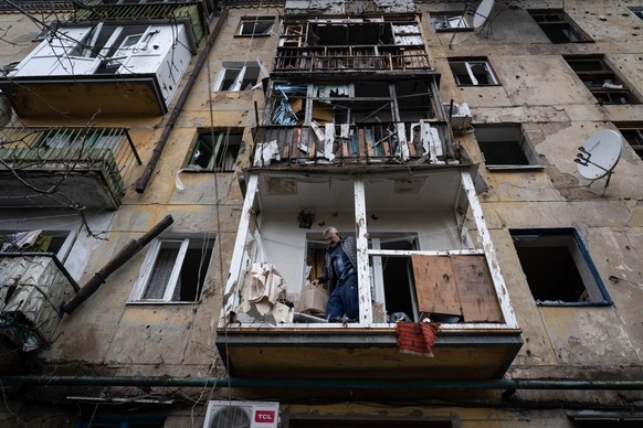 14.04.2023, Ukraine, Slowjansk: Ein Bewohner r�umt Schutt von seinem Balkon in einem besch�digten Geb�ude. Kurz vor dem orthodoxen Osterfest an diesem Sonntag ist die Ukraine erneut von einem schweren ...