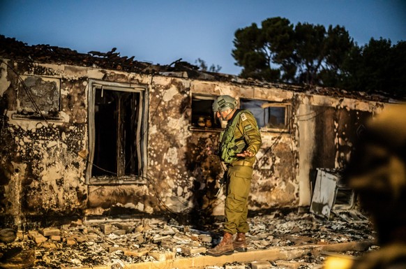 11.10.2023, Israel, Kibbuz Be&#039;eri: Ein israelischer Soldat inspiziert ein zerstörtes Haus in einem Kibbuz, der von Terroristen der Hamas überfallen worden war, nachdem die israelische Armee die K ...