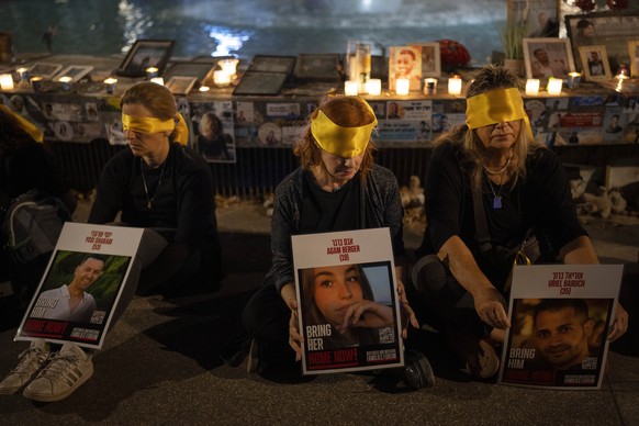 dpatopbilder - 24.10.2024, Israel, Tel Aviv: Aktivisten sitzen mit verbundenen Augen, um ein Jahr im hebräischen Kalender seit dem grenzüberschreitenden Hamas-Angriff auf Israel zu markieren. Sie prot ...