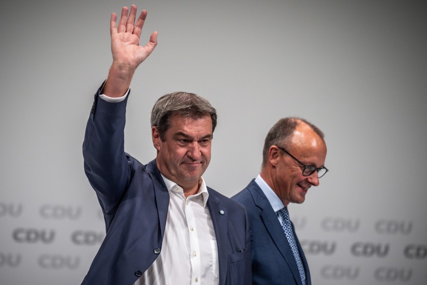 10.09.2022, Niedersachsen, Hannover: Markus Söder (CSU, l), Ministerpräsident von Bayern und CSU-Vorsitzender, winkt neben Friedrich Merz, CDU Bundesvorsitzender, beim Bundesparteitag der CDU. Beim zw ...