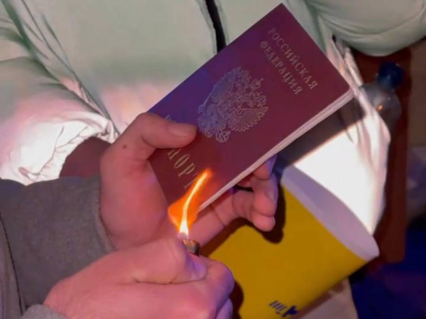 Ein russischer Pass wird verbrannt.