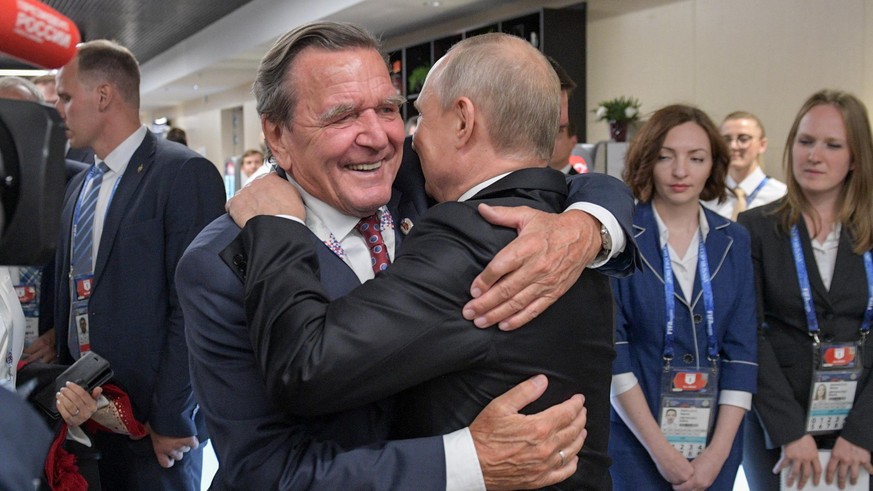 MOSCOW, RUSSIA - JUNE 14, 2018: Russia&#039;s President Vladimir Putin (R) hugs Gerhard Schroeder, Chairman of the Shareholders Committee with Nord Stream 2 AG and former German chancellor, at the ope ...