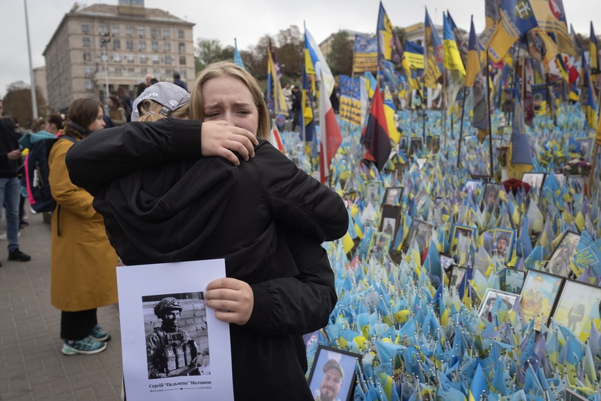 dpatopbilder - 01.10.2024, Ukraine, Kiew: Zwei Menschen umarmen sich bei einer landesweiten Schweigeminute zum Gedenken an die gefallenen Soldaten, die ihr Heimatland im Krieg mit Russland verteidigt  ...