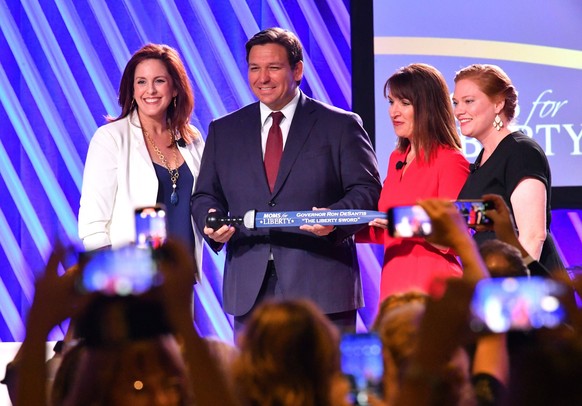 Syndication: USA TODAY Florida Gov. Ron Desantis, center, is presented The Sword of Liberty by Moms for Liberty co-founders Tiffany Justice, left, Tina Descovich, second from right and executive direc ...
