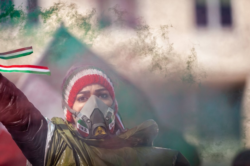 Protest against poisonings and the nuclear deal with Iran A demonstrator in a gas mask releases green smoke during a rally outside the US State Department against the Islamic regime in Iran. The gas m ...