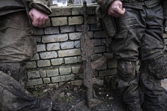 ARCHIV - 08.03.2023, Ukraine, Tschassiw Jar: Ein mit Schlamm verschmutztes Gewehr ist vor ukrainischen Soldaten zu sehen, die gerade von Schützengraben von Bachmut zurückkommen. Foto: Evgeniy Maloletk ...
