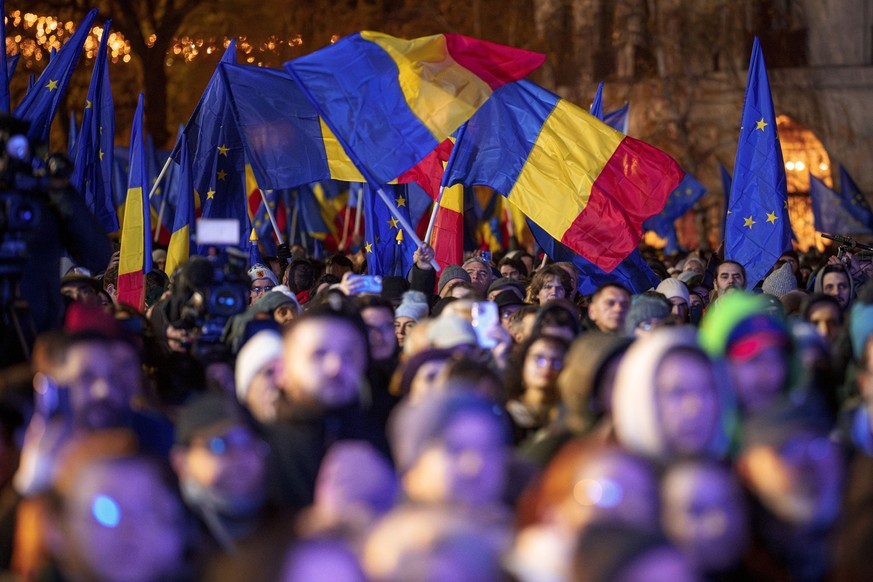 05.12.2024, Rumänien, Bukarest: Menschen schwenken rumänische und EU-Flaggen während einer pro-europäischen Kundgebung vor den Präsidentschaftswahlen am 8. Dezember. Foto: Andreea Alexandru/AP/dpa +++ ...