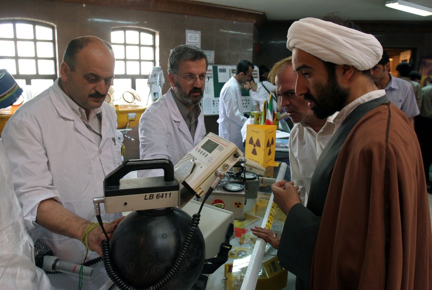 FILE - In this May 2, 2006 file photo, Iranian technicians explain a piece of equipment to a clergyman during an exhibition of Iran's Atomic Energy Organization at the Qom University in Qom, Iran. Ira ...