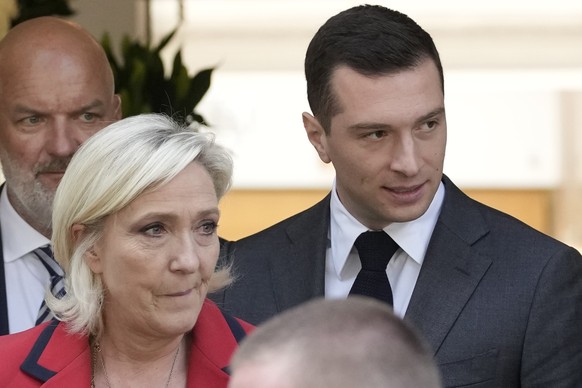 FILE - Far-right National Rally party president Jordan Bardella, right, leaves with far-right leader Marine Le Pen after a press conference, Monday, June 24, 2024 in Paris. Both Le Pen and Bardella ha ...