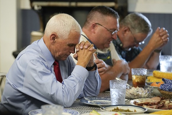 Republican presidential candidate and former Vice President Mike Pence prays before lunch during a stop at the Indiana State Fair, Wednesday, Aug. 2, 2023, in Indianapolis. (AP Photo/Darron Cummings)