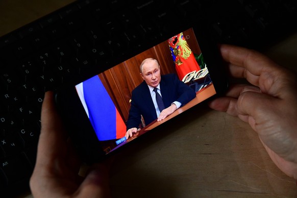 Russia Putin Address Broadcast 8279042 21.09.2022 A person watches from a mobile phone as Russian President Vladimir Putin addresses the nation, in Yekaterinburg, Russia. Putin on September 21 announc ...