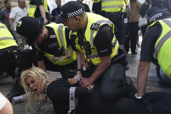 Police officers detain a woman during a protest in Nottingham, England&#039;s Market Square Saturday Aug. 3, 2024, following the stabbing attacks on Monday in Southport, in which three young children  ...