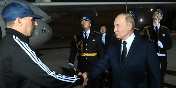 01.08.2024, Russland, Moskau: Der russische Präsident Wladimir Putin (r) begrüßt den vom Westen freigelassenen russischen Gefangenen Wadim Krassikow nach dessen Ankunft auf dem Regierungsflughafen Vnu ...