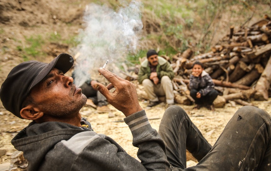 December 7, 2021, Gaza, Palestine: One of Raed Abd El-Aal s workers smokes a cigarette and takes a rest at the workshop..Raed Abd El-Aal 52 years old, has been working as a lumberjack for thirty years ...