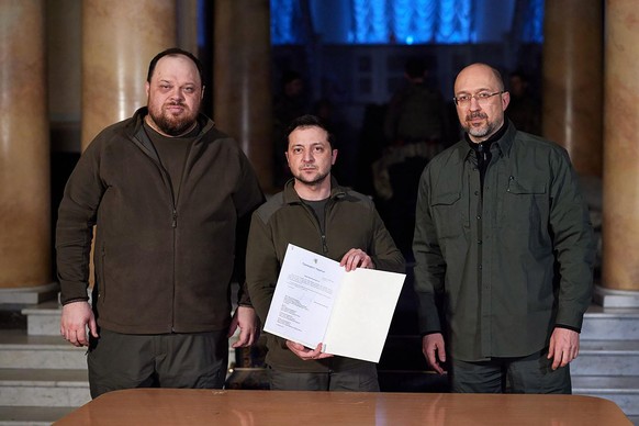 Ukrainian President Volodymyr Zelenskiy (C) with Prime Minister Denys Shmygal (R) and Parliament Speaker Ruslan Stefanchuk after they signed an official request for Ukraine to join the European Union, ...