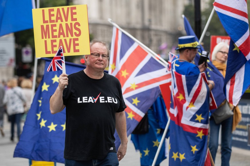 September 5, 2018 - London, London, UK - London, UK. A pro-Brexit demonstrator passes a group of anti-Brexit demonstrators outside the Houses of Parliament, as two Brexit demonstrations happen simulta ...