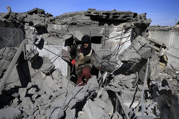 21.10.2023, Libanon, Rab El Thalathine: Eine Frau holt pers�nliche Gegenst�nde aus den Ruinen von H�usern, die durch israelische Luftangriffe zerst�rt wurden. Seit den Terrorattacken der islamistische ...