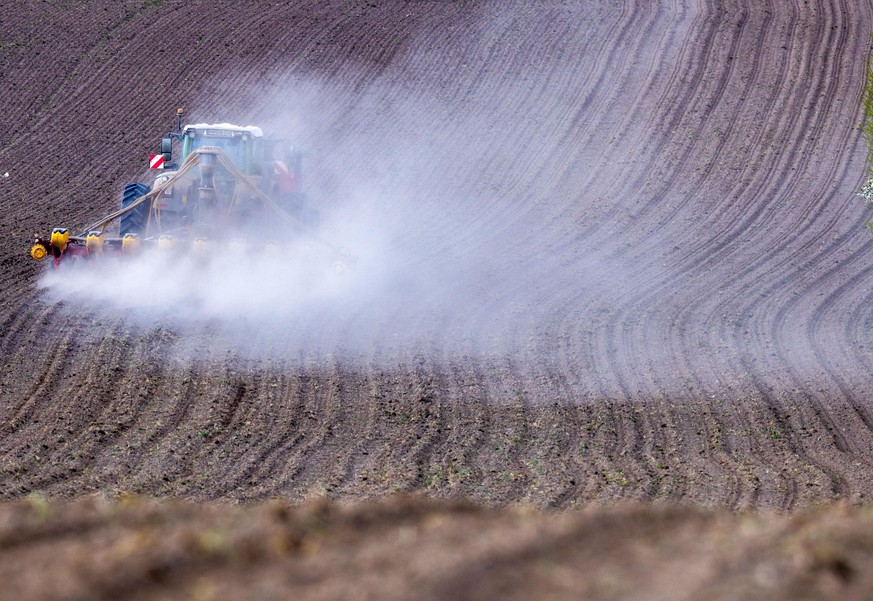 Ein Traktor in Mecklenburg-Vorpommern beackert ein Feld. Wegen der starken Trockenheit staubt es.