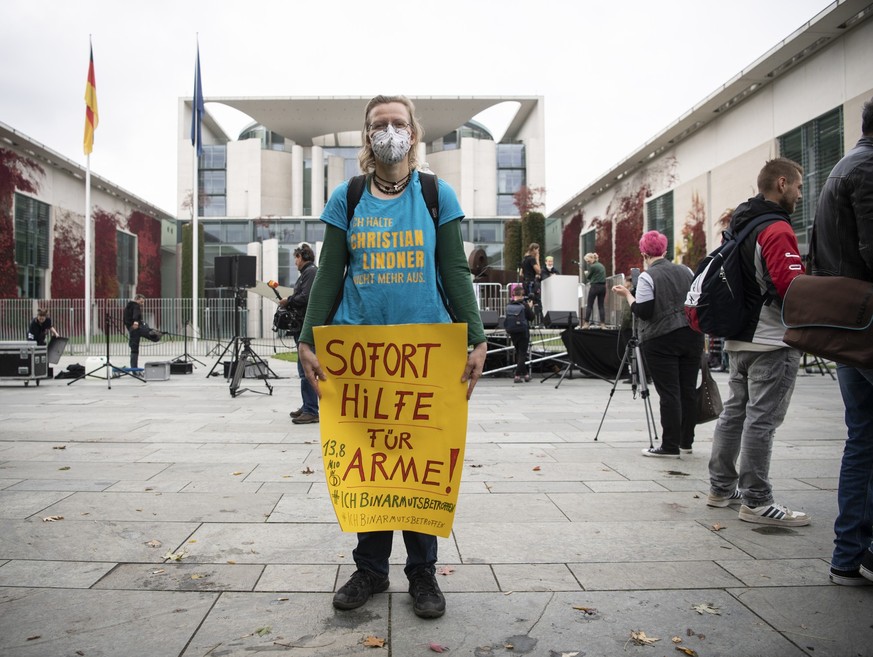 15.10.2022, Berlin: Eine Teilnehmerin der Kundgebung der Initiative #ichbinarmutsbetroffen steht mit einem Plakat mit der Aufschrift &quot;Sofort Hilfe für Arme&quot; am Bundeskanzleramt. #IchBinArmut ...