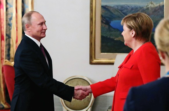Russian President Vladimir Putin, left, greets German Chancellor Angela Merkel during their meeting at the G20 summit in Buenos Aires, Argentina, Saturday, Dec. 1, 2018. (Mikhail Klimentyev, Sputnik,  ...