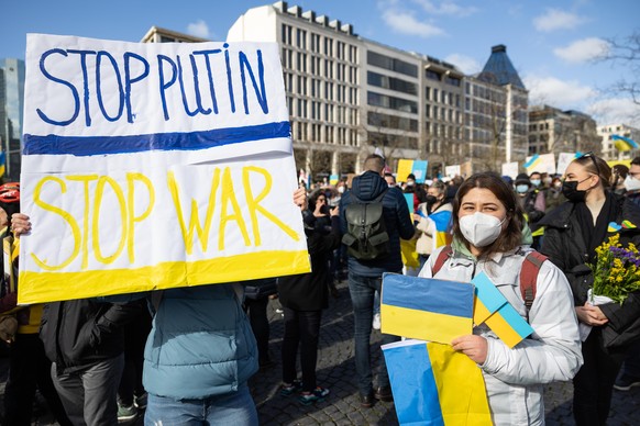 Menschen halten auf der Veranstaltung «Solidarität mit der Ukraine - Frieden in Osteuropa» von Bündnis 90/Die Grünen am Rathenauplatz Schilder mit der Aufschrift «Stop Putin - Stop War» und ukrainisch ...