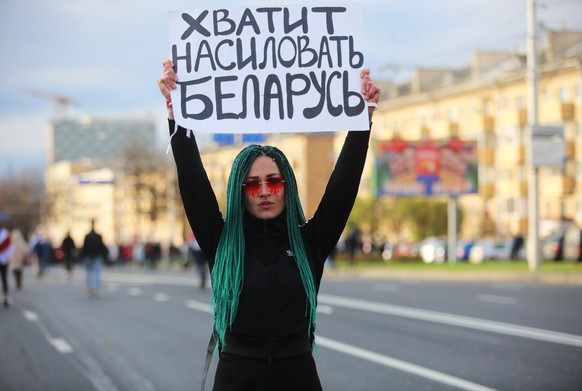A demonstrator holds a placard reading &quot;Stop raping Belarus&quot; during an opposition rally to reject the presidential election results in Minsk, Belarus October 18, 2020. REUTERS/Stringer
