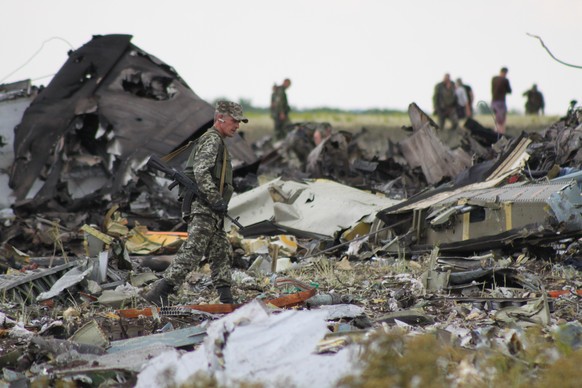 Ein russischer Soldaten patrouilliert dort, wo kurze Zeit vorher ukrainische Militärtransportflugzeuge von pro-russischen Separatisten abgeschossen wurden. Alle 49 Besatzungsmitglieder der Flugzeuge sterben.