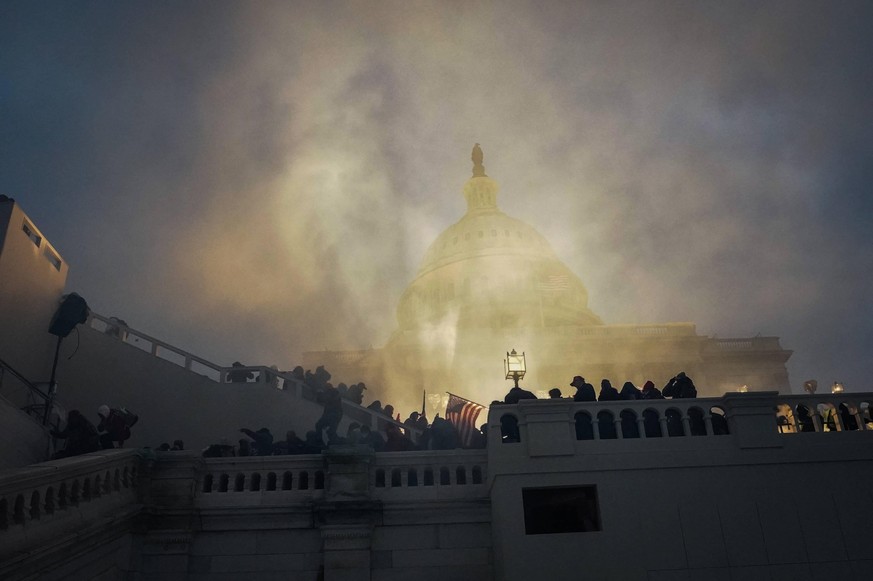 January 6, 2021, Washington, District of Columbia, USA: A flash bang grenade lights up the Capital Building as Trump supporters storm and rally at the building protesting the 2020 election results in  ...