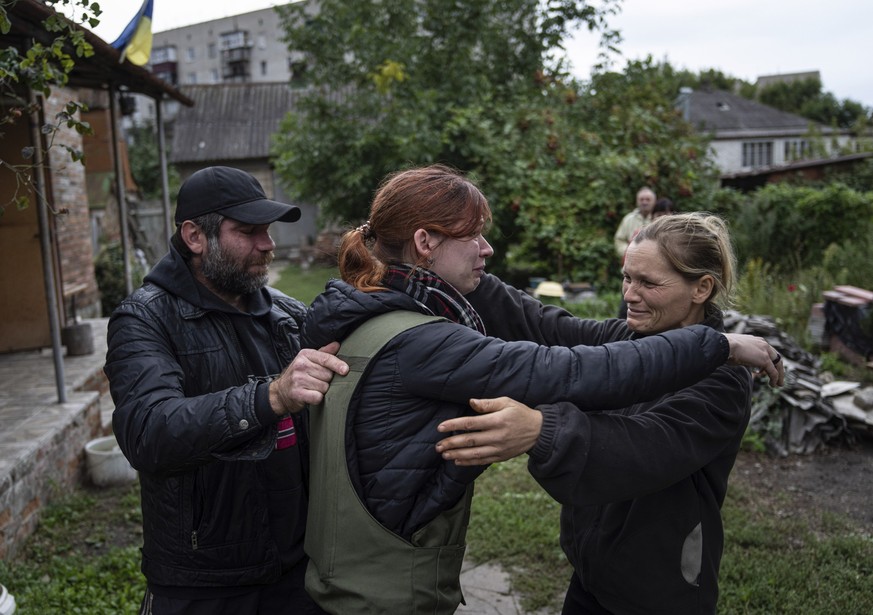 Maria, center, hugs her parents Marina and Alexander during their first meeting after seven months since the beginning of the war in the recently retaken town of Izium, Ukraine, Wednesday, Sept. 14, 2 ...