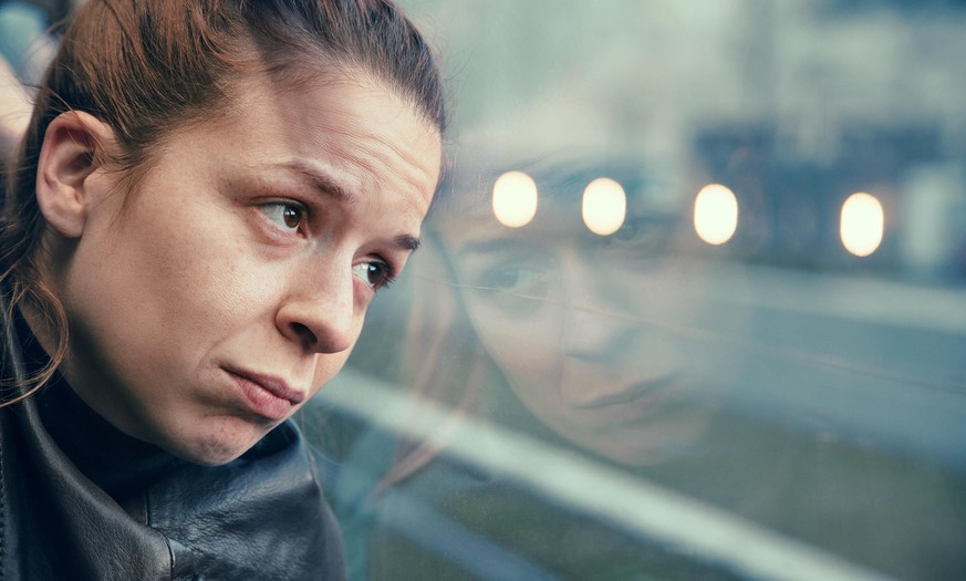 A woman in streetcar alone and depressed