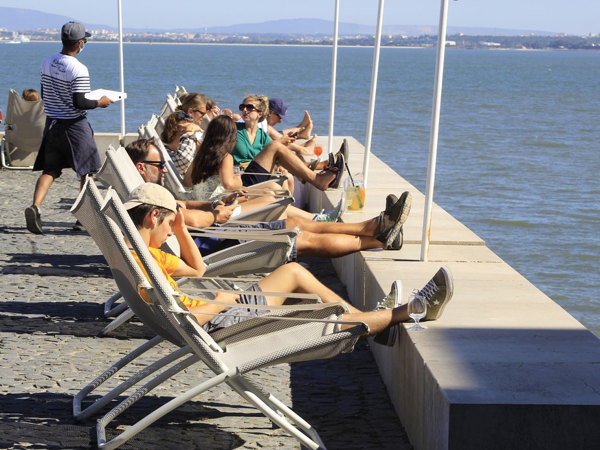 01.07.2021, Portugal, Lissabon: Menschen sitzen in Liegest