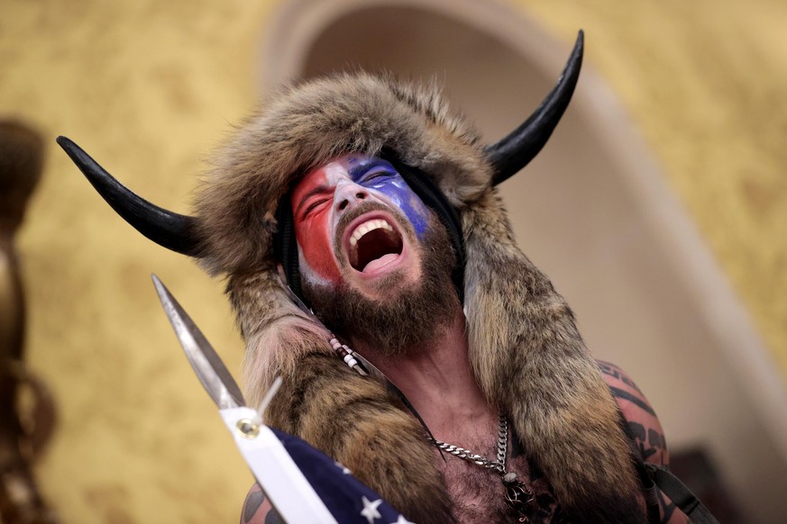 WASHINGTON, DC - JANUARY 06: A protester screams &quot;Freedom&quot; inside the Senate chamber after the U.S. Capitol was breached by a mob during a joint session of Congress on January 06, 2021 in Wa ...