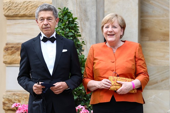 ARCHIV - 25.07.2021, Bayern, Bayreuth: Angela Merkel, damals Bundeskanzlerin, und ihr Mann Joachim Sauer stehen vor dem Bayreuther Festspielhaus. (zu dpa: