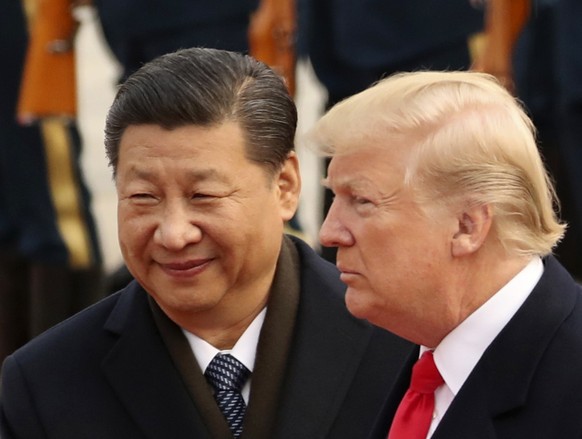 FILE - In this Nov. 9, 2017, file photo, U.S. President Donald Trump and Chinese President Xi Jinping participate in a welcome ceremony at the Great Hall of the People in Beijing, China. This last wee ...
