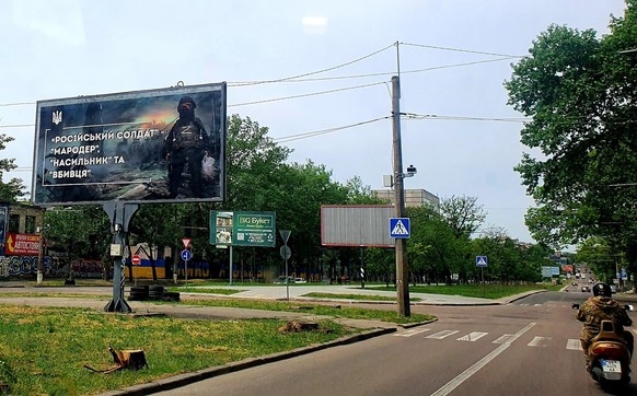 "Russischer Soldat" steht auf dem Plakat mit dem Ork darauf in Mykolajiw. Und darunter: "Rumtreiber, Vergewaltiger und Mörder."