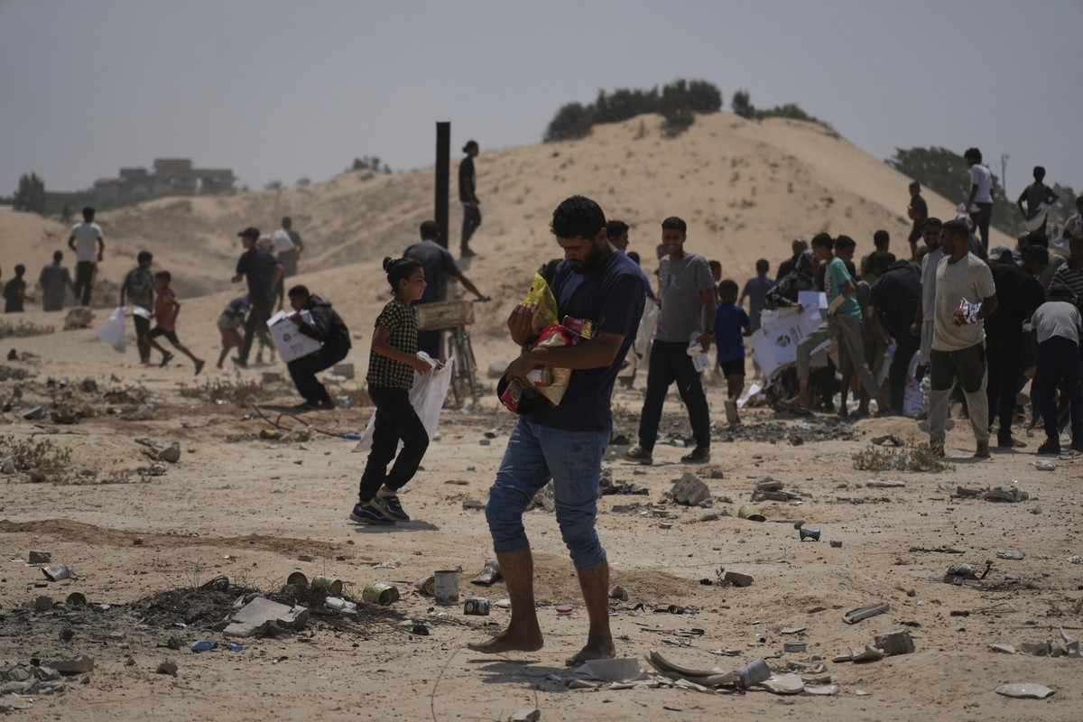 Palestinians collect humanitarian aid packages from the United Arab Emirates after they were airdropped into Deir al-Balah, in central Gaza Strip, Saturday, Aug. 9, 2025. (AP Photo/Abdel Kareem Hana)