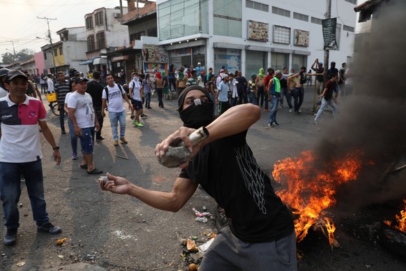 A demonstrator throws rocks during clashes with the Bolivarian National Guard in Urena, Venezuela, near the border with Colombia, Saturday, Feb. 23, 2019. Venezuela's National Guard fired tear gas on  ...
