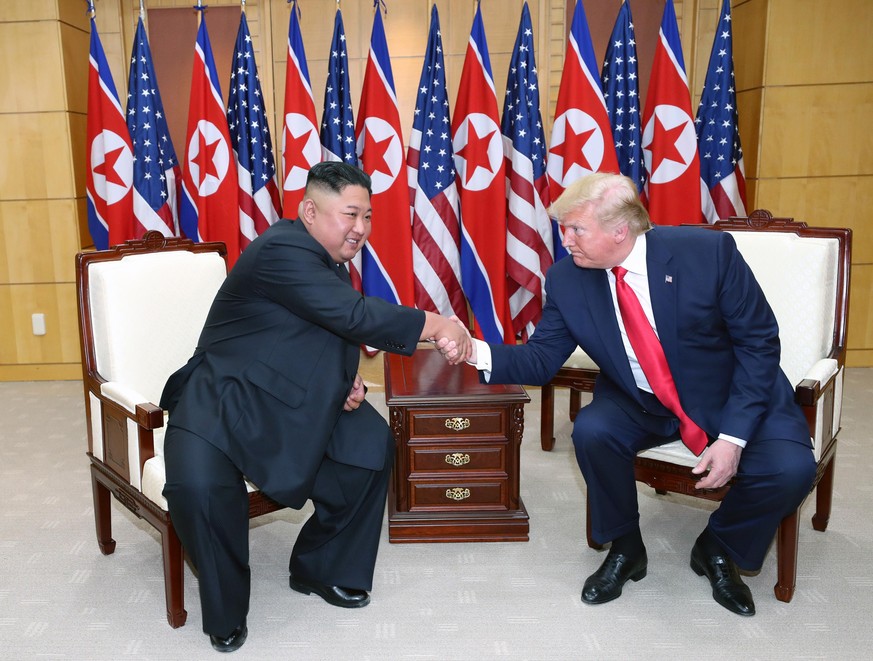 PANMUNJOM, SOUTH KOREA - JUNE 30 (SOUTH KOREA OUT): A handout photo provided by Dong-A Ilbo of North Korean leader Kim Jong Un and U.S. President Donald Trump attend a meeting on the south side of the ...