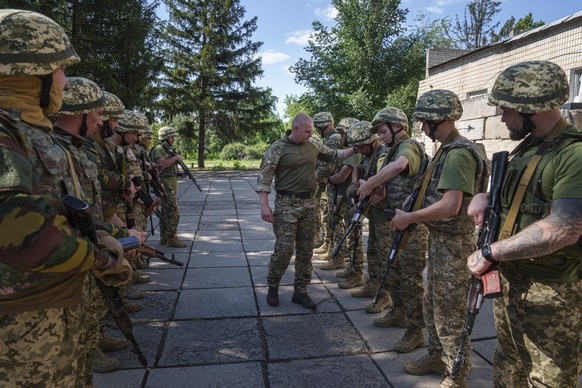 A Ukrainian military instructor of Arey Battalion checks weapons of convict prisoners who have joined the Ukrainian army during training at the polygon, in the Dnipropetrovsk region, Ukraine, Saturday ...