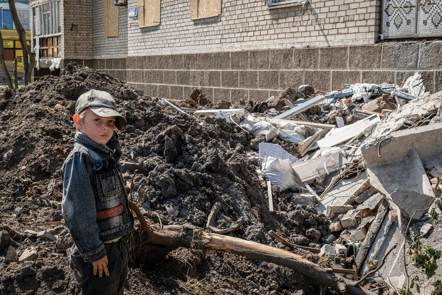 May 24, 2022, Bakhmut, Dontesk Oblast, Ukraine: A child stands in front of a residential building destroyed by Russian artillery strikes in Bakhmut, Donbas. As Bakhmut stands as a key city to Ukrainia ...