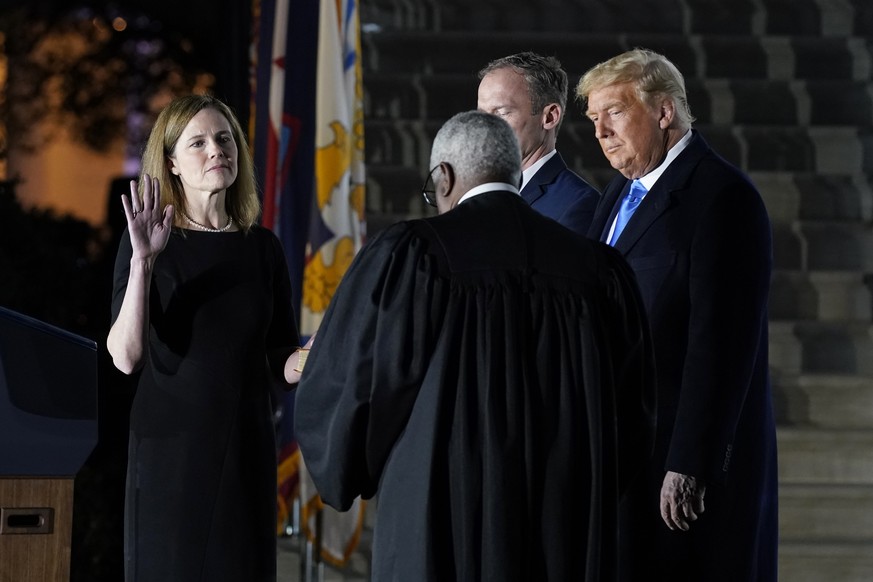 President Donald Trump watches as Supreme Court Justice Clarence Thomas administers the Constitutional Oath to Amy Coney Barrett on the South Lawn of the White House in Washington, Monday, Oct. 26, 20 ...