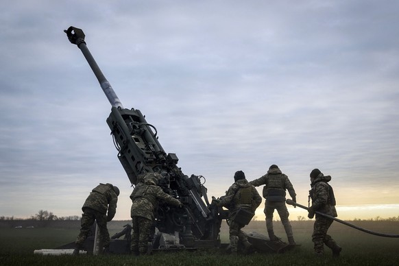 FILE - Ukrainian soldiers prepare a U.S.-supplied M777 howitzer to fire at Russian positions in Kherson region, Ukraine, Jan. 9, 2023. A rapidly expanding group of U.S. and allied troops and contracto ...