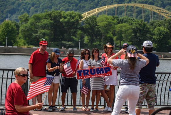 PITTSBURGH, PA - JULY 04: A group of Trump supporters along the Allegheny River North Shore pose for photos while waiting for boats taking part in a boat parade for the re-election of President Donald ...