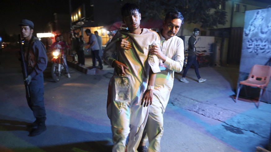 An injured boy is held up outside a hospital following a deadly attack in Kabul, Afghanistan, Wednesday, Sept. 5, 2018. Twin bombings at a wrestling training center in a Shiite neighborhood of Afghani ...