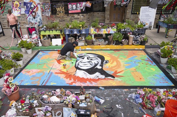 FILE - Antonio Jenkins paints a mural of George Floyd at the site where he was murdered by a police officer in 2020 at George Floyd Square in Minneapolis, May 25, 2024. (Alex Kormann/Star Tribune via  ...