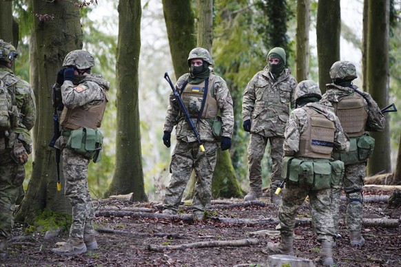 01.02.2023, Großbritannien, London: Ukrainische Soldaten stehen zusammen bei der Ausbildung auf Salisbury Plain in Wiltshire, wo die australischen Streitkräfte die vom Vereinigten Königreich geführte  ...